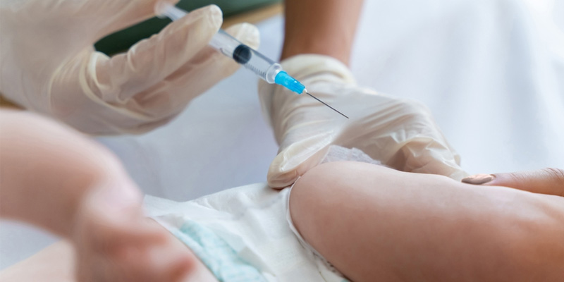 Ôm trẻ vào lòng khi trẻ sơ sinh tiêm vắc xin viêm gan B quấy khóc